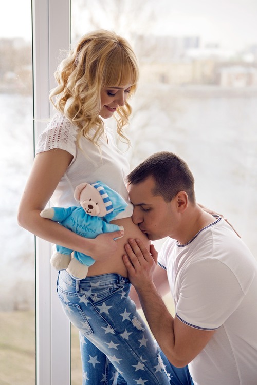 pregnant girl standing with her husband